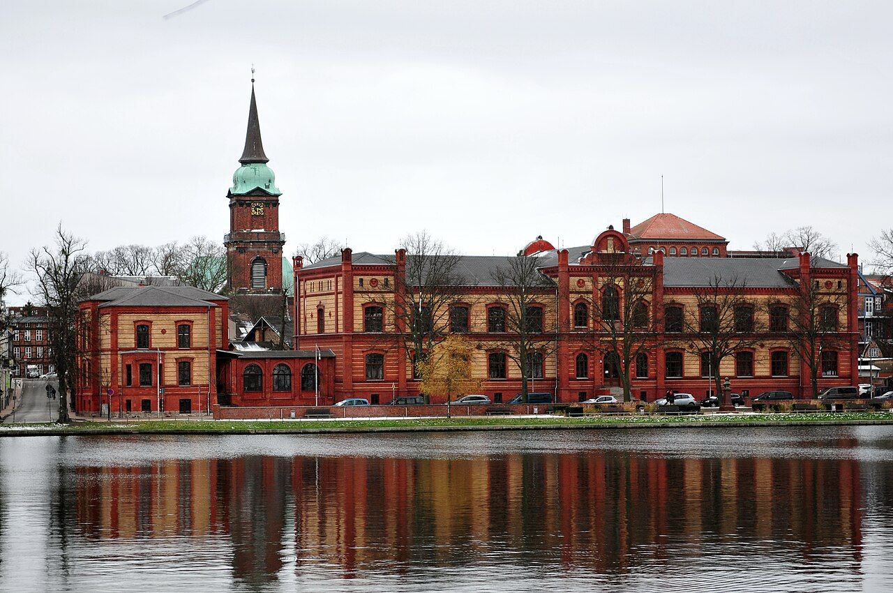 Arsenal am Pfaffenteich in Schwerin, roter Backsteinbau, gespiegelt im Wasser